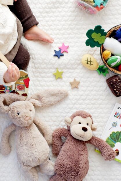 Baby playing with plushies.